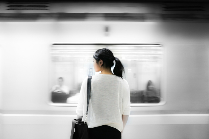 viajando en transporte público, niña frente al metro, niña con camiseta blanca, pantalón negro