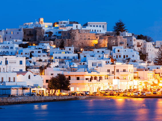 Atardecer tranquilo en la isla de Naxos, una de las mejores islas de Grecia para visitar, farolas reflejadas en las tranquilas aguas del mar y tranquilas casas blancas 