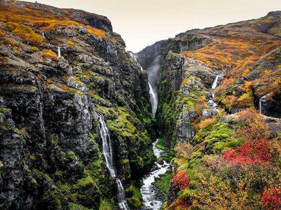 excursión por la cascada de Glymur, una de las mejores de Islandia, con muchas rocas oscuras con musgo verde claro