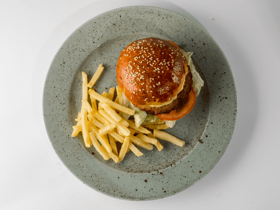 Combinación de hamburguesas y papas fritas servida en un plato gris manchado en uno de los mejores restaurantes de Islandia, Bautinn