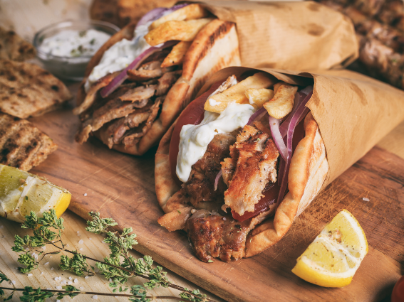 Comida griega envuelta en pan de pita para un pedazo sobre las mejores cosas que hacer en Grecia
