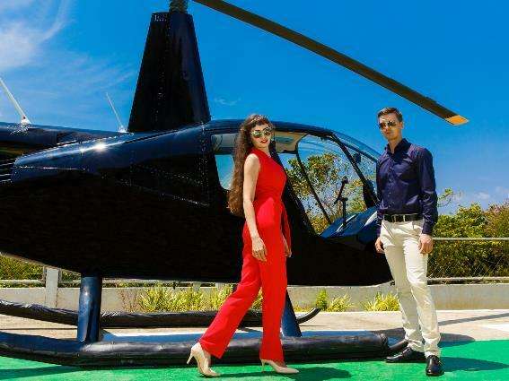Elegante pareja en un helicóptero para una pieza sobre las mejores cosas que hacer en Santorini