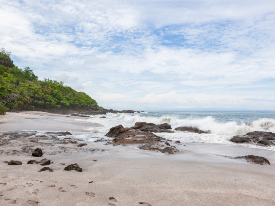 Enormes olas rompiendo contra las rocas de Playa Montezuma, una de las mejores playas de Costa Rica