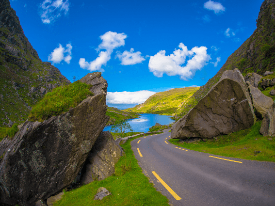 Enormes rocas a lo largo de una pequeña carretera y un hermoso paisaje en Gap of Dunloe Drive en Ring of Kerry, titulado como uno de los mejores lugares para visitar en Irlanda