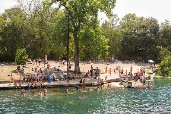 La gente nada en la piscina al aire libre en Barton Springs Pool en Austin, Texas, en un caluroso y soleado día de verano.