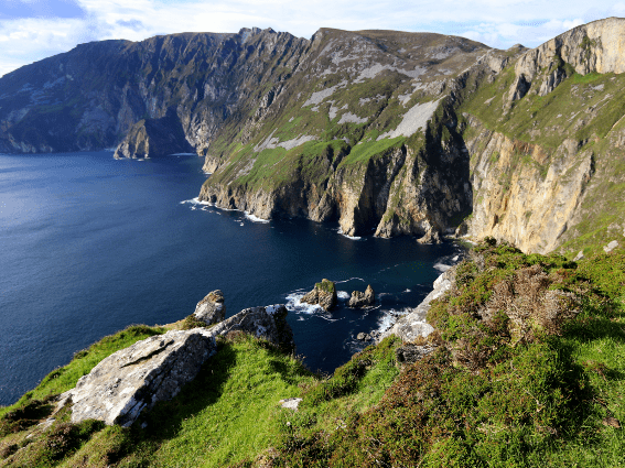 Los acantilados marinos más altos de Europa en Slieve League, conocido como uno de los mejores lugares para visitar en Irlanda, con un océano tranquilo a sus pies