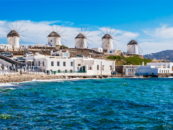 Los turistas se reunieron alrededor de los cinco icónicos molinos de viento blancos en Mykonos, fotografiados desde la vista azul ondulada como una pieza en las mejores islas de Grecia para visitar.