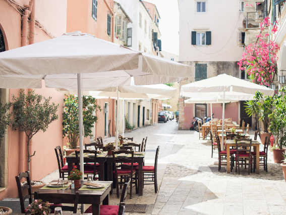 Mesas exteriores frescas y pintorescas en Corfú, una de las mejores cosas que hacer en Grecia