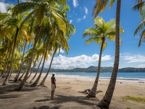 Mujer de pie mirando al océano en Samara en Costa Rica, uno de los mejores lugares para alojarse allí