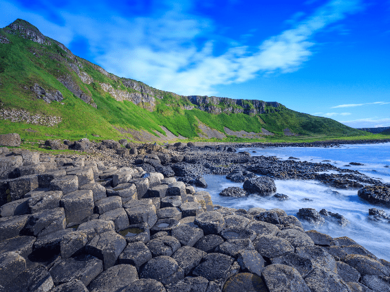 Parches verdes de hierba y raras rocas hexagonales naturales en Giant's Causeway Coast, patrimonio de la UNESCO y uno de los mejores lugares para visitar en Irlanda