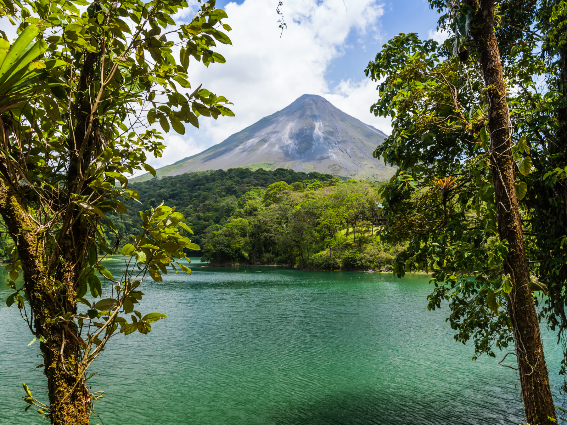 Vista fresca del Volcán Arenal a través de los árboles, uno de los mejores lugares para visitar en Costa Rica
