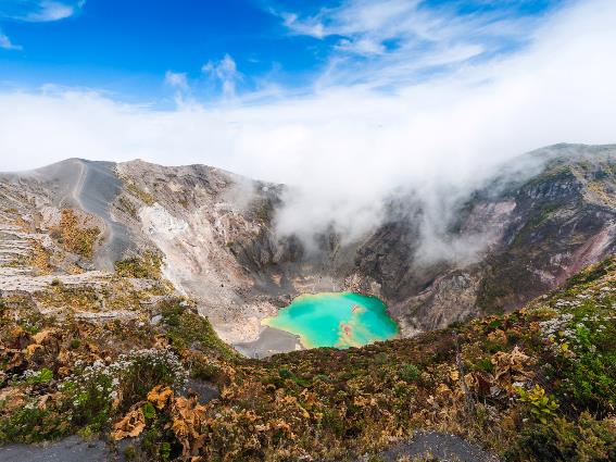 Volcán Irazú con vapor sobre el agua y agua verde azulado, uno de los mejores lugares para visitar en Costa Rica